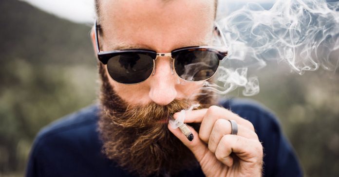 man with beard smoking vape