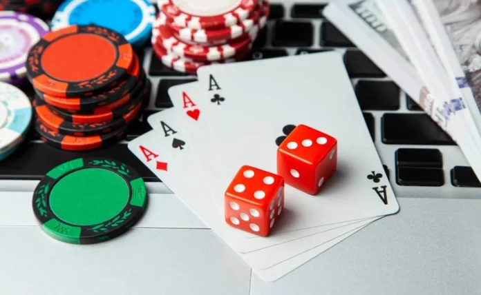aces cards with dice and casino chips on top of keyboard for online gambling